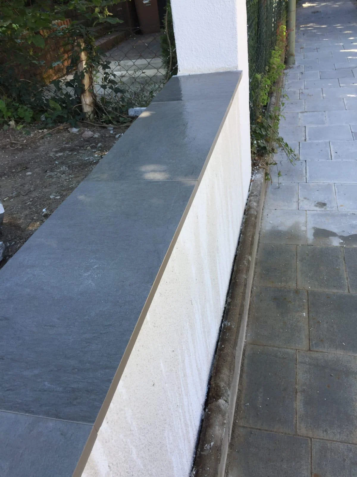 Weiße Gartenmauer mit grauer Abdeckung